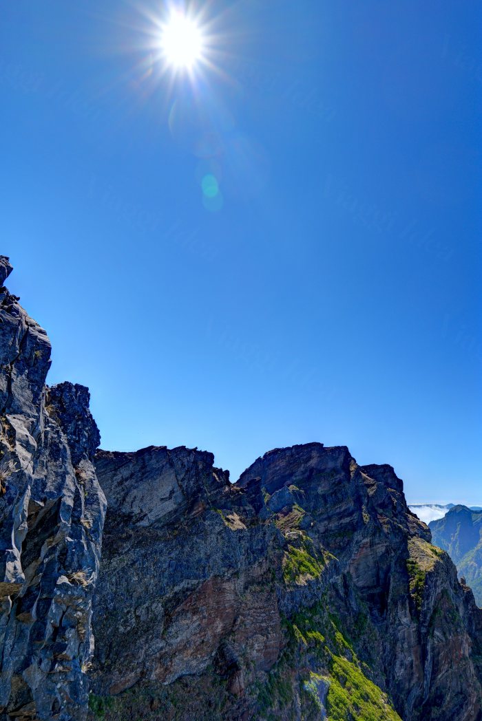 Sole che splende sopra scogliere rocciose con vegetazione verde
