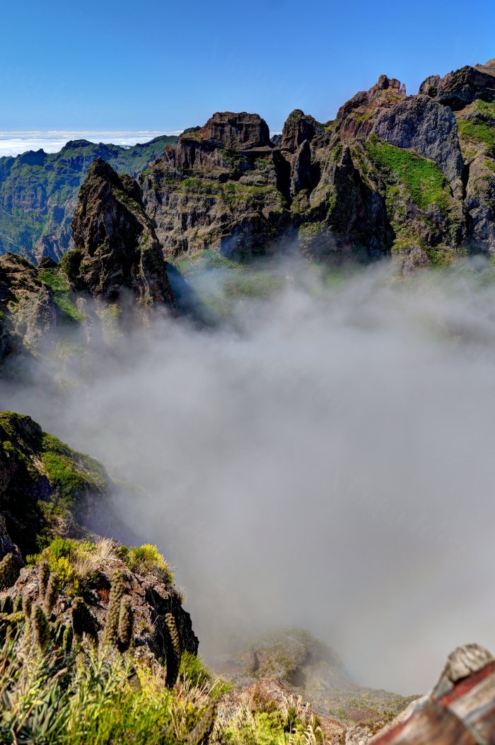 Montagne rocciose con vegetazione e nuvole basse